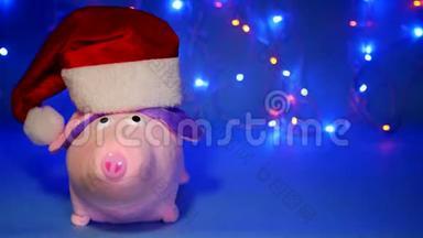 粉红色的猪塞玩具，戴着蓝色背景的红色圣诞老人帽子，新年2019，圣诞节，<strong>猪年</strong>