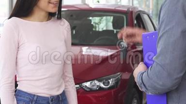一个幸福的女人收到车钥匙时被人弯下腰，和推销员握手