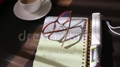 日记、眼镜、自拍棒、桌子上的咖啡
