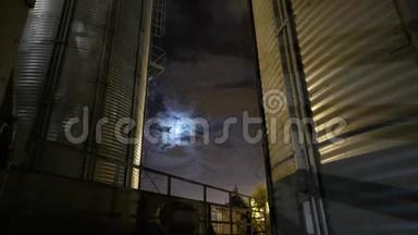 晚上谷物码头的时间点。天上的月亮和云。电梯的<strong>金属罐</strong>。谷物干燥厂