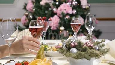 餐厅概念。 新年和圣诞大餐桌。 女人的手拿着，握着，然后放一杯