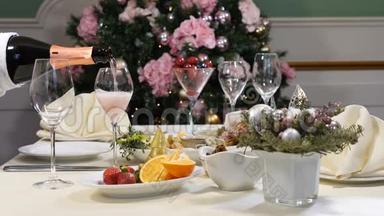 餐厅概念。 新年和圣诞大餐桌。 戴手套的侍者从瓶子里倒出香槟。 切片