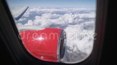 从舷窗到云层的景色。 从飞机的窗口看飞机的机翼与喷气发动机。