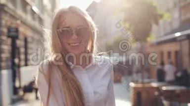 迷人的年轻女子，一头华丽的棕色头发，戴着时髦的太阳镜。迷人的年轻女士正在城里奔波