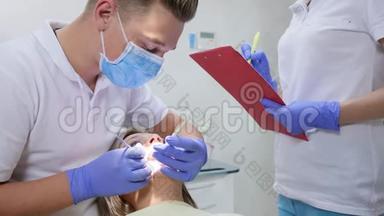 正畸医生用牙具看着女人的嘴，旁边的护士在门诊记事本上写诊断
