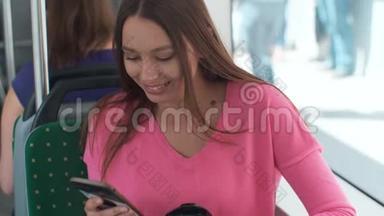 年轻快乐的女人在旅行中坐在靠近窗户的<strong>公共交通工具</strong>上使用智能手机。