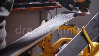 滑雪板<strong>保养</strong>维修理念.. 车间工人正在打蜡和修理滑雪板和滑雪板