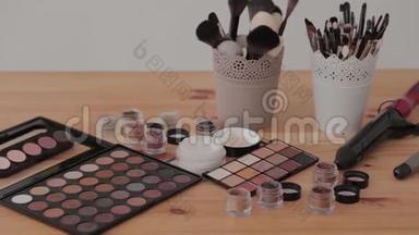 在木制桌子上的化妆室里的专业化妆包。