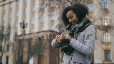 漂亮的非裔美国学生女孩检查<strong>智能</strong>手表并在大学附近走开