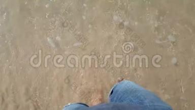 一个人光着脚从沙滩走向大海