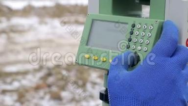 近距离手指，<strong>推动</strong>测量器按钮在工作中测量距离。 冬季施工的概念