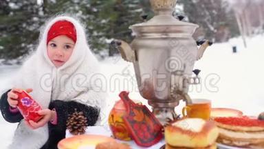 一个穿着裘皮<strong>大衣</strong>、戴着俄罗斯风格围巾的小女孩坐在<strong>节</strong>日的餐桌旁，扮演着一个俄罗斯的马崔什卡