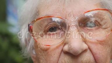 多莉在户外戴眼镜的老妇人。 一位有<strong>皱纹</strong>的老太太的<strong>眼睛</strong>。 特写肖像画