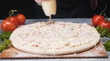 大瓶中用白酱覆盖比萨饼表面的厨师特写。 框架。 意大利比萨的制作