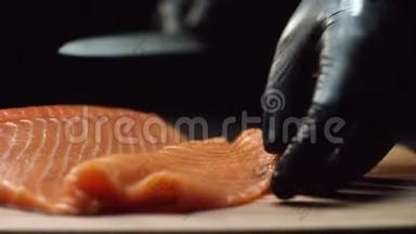 在寿司吧里，在手套里为寿司厨师切鲜鲑鱼。 切割三文鱼片
