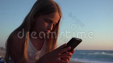 孩子在<strong>玩</strong>智能<strong>手机</strong>，日落时在海滩上<strong>玩</strong>，女孩在<strong>玩</strong>平板电脑