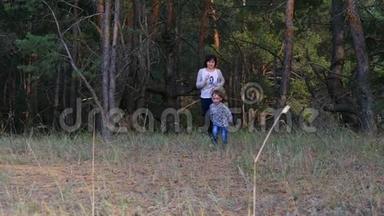 母亲和孩子正在松林中慢悠悠地跑来跑去，玩得很开心，一个活跃的家庭