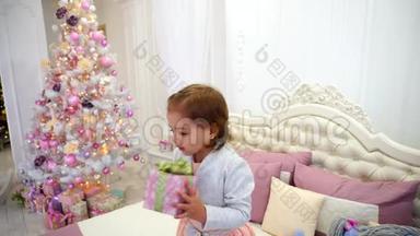 小女孩新年快乐，跳床在<strong>儿童房</strong>`粉红背景圣诞树与玩具。