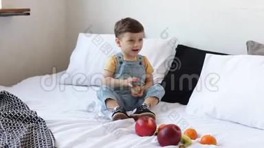 孩子有一张满是有机食物的桌子。 快乐的幼儿吃健康的沙拉和<strong>水果</strong>。 <strong>宝宝</strong>在苹果，香蕉之间选择，