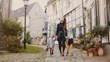 美丽的女人带着两个孩子<strong>走路</strong>。 牵着手。 欧洲母亲，女孩和<strong>男孩</strong>在一起。 哈廷根，德国4K。