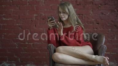 微笑的女孩在家放松，她正在与她的智能手机连接和社交网络