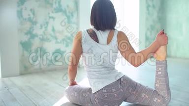 瑜伽垫女人伸展臀部，腿筋<strong>肌肉</strong>，<strong>腿部肌肉</strong>用鸽子姿势伸展。 20岁