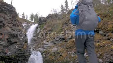 一个人带着背包沿着山区路线旅行。 他到达了美丽的瀑布，看了看，<strong>继续前进</strong>。 积极主动