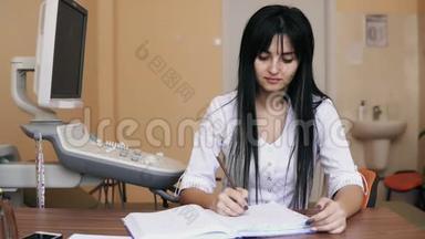 年轻女医生坐在办公桌前，在诊所开处方，<strong>填写表格</strong>，<strong>填写</strong>健康