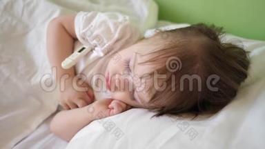 婴儿体温在医院病房用体温计测量.. 孩子睡在医院病房的白色床上。