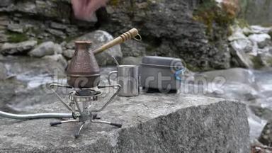 在便携式燃气燃烧器上，有一个用来冲泡咖啡的水壶。 糖被扔进里面。 在河边野餐