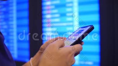 <strong>旅游</strong>妇女使用手机在机场离港板附近检查她的航班时间。 4K慢动作。 <strong>泰国曼谷</strong>。
