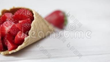 新鲜的草莓，从华夫饼杯里倒出来，放在浅色的木制背景上。 浆果、草莓、水果冰淇淋