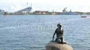 阳光明媚的哥本哈根现代城市景观背景下的<strong>小美人鱼</strong>纪念碑