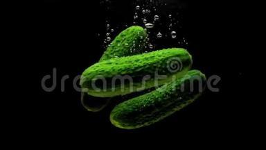 绿色黄瓜在黑色背景下<strong>落入</strong>透明水