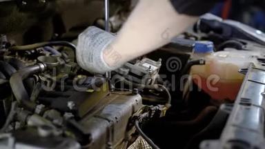 汽车修理厂的工人用扳手拧动汽车内部的小能量螺栓