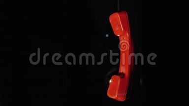 红色电话接收器从复古电话挂在电线上的<strong>黑色</strong>背景