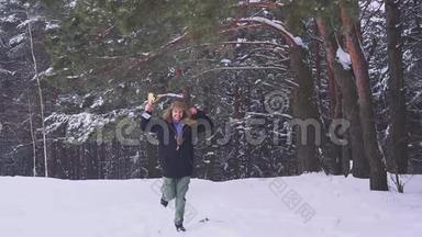 快乐的人手里拿着奖品，微笑着跑到镜头前，在冬天的森林里快乐。 体育运动的胜利