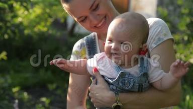 <strong>妈妈</strong>带着小女孩在花园里，年轻<strong>的微笑妈妈</strong>抱着女儿在户外玩耍