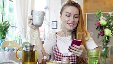 女人边喝茶边用手机微笑。