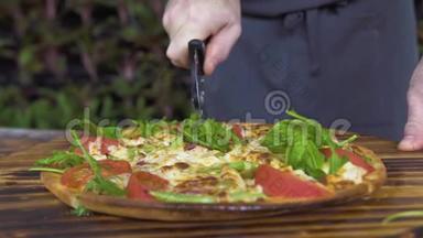 在披萨店的木桌上用滚刀将披萨切好。 厨师切意大利热比萨饼