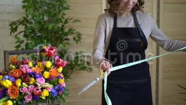 花的组成。粉红色，绿色，洗脸盆，蓝色。美丽的豪华花束在女人的手中。工作