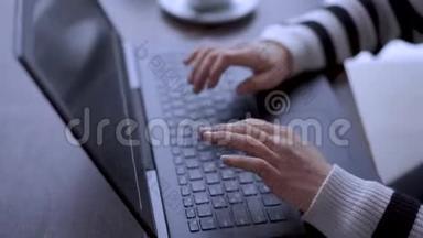 一个年轻的女人在咖啡馆用笔记本电脑工作。自由主题。使用笔记本