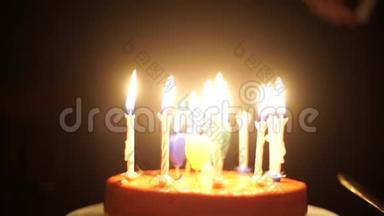 美丽的黑发年轻女子许愿，在生日巧克力蛋糕上吹蜡烛，中镜头