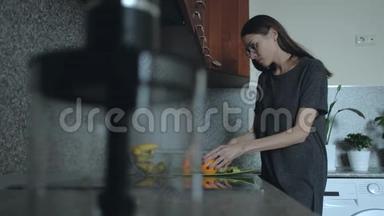 女人早上在厨房准备早餐。 一个女人在桌子上<strong>切水果</strong>，橘子。