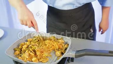 一个女人正在锅里搅拌鸡肉和蔬菜的炒米粉。
