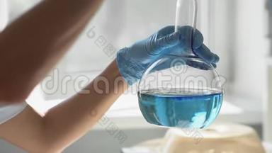 实验室实验中的一个<strong>烧瓶</strong>的特写，蓝色液体旋转到<strong>烧瓶</strong>中。