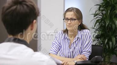 在办公室里，戴<strong>眼镜</strong>的女人会和男人进行关于<strong>招聘</strong>的面试。
