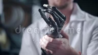 一位科学家工程师正在测试一种电子仿生假肢。 他用<strong>机械</strong>手<strong>臂</strong>的塑料手指