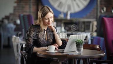 一个漂亮的女人在咖啡馆里用<strong>笔记本</strong>电脑工作。 一个快乐的女孩，她收到了<strong>笔记本</strong>电脑`<strong>键盘</strong>上的指纹