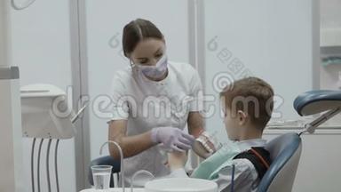 牙医教一个坐在口腔椅上的小男孩如何刷牙